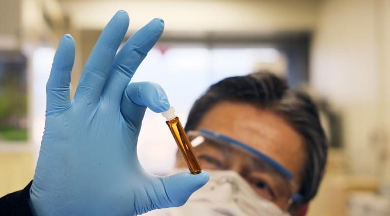 Japanese scientist with vaccine vial (CC BY 2.0 Japanexperterna.se)