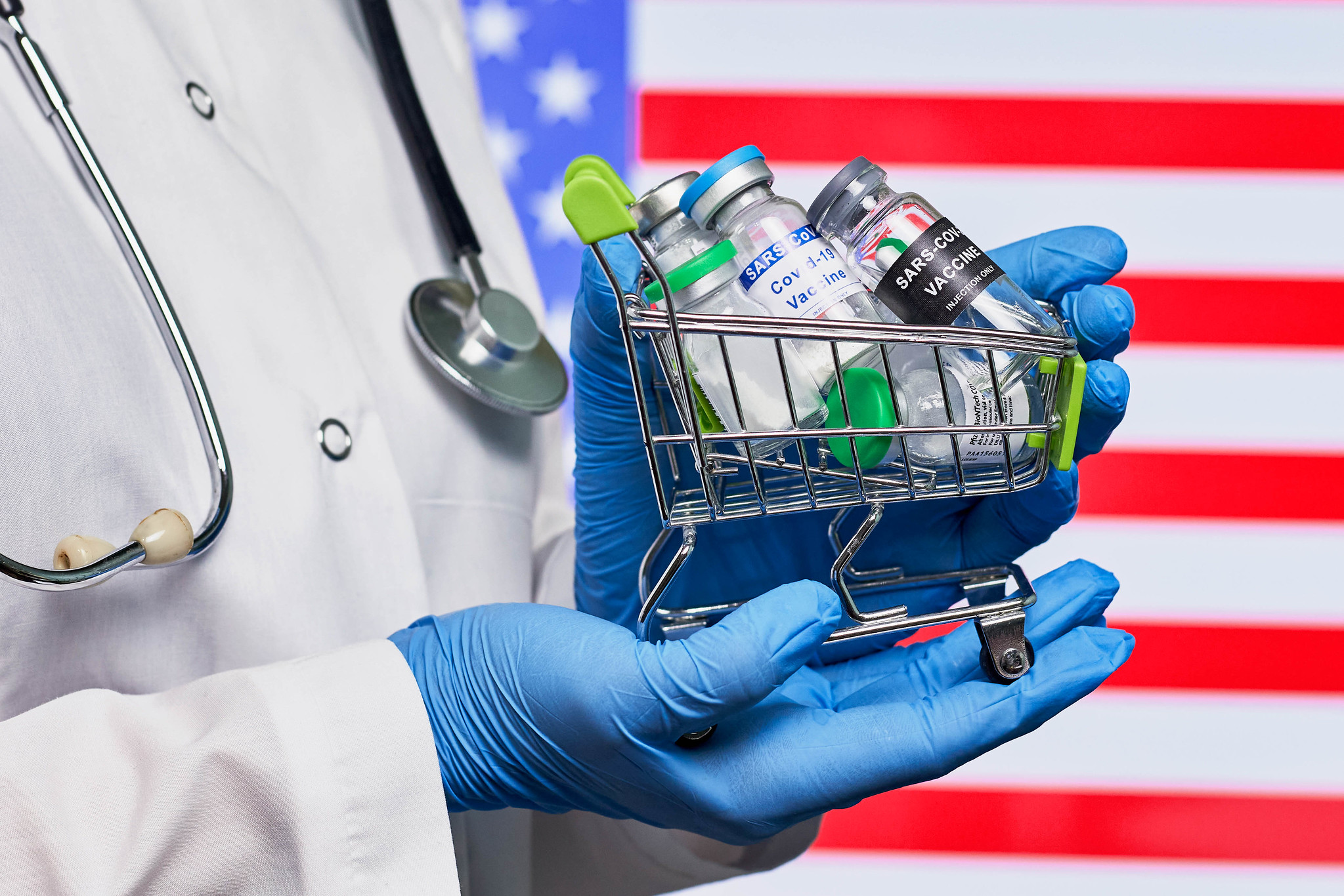 Various vaccines in front of an American Flag (CC BY 2.0 Marco Verch)