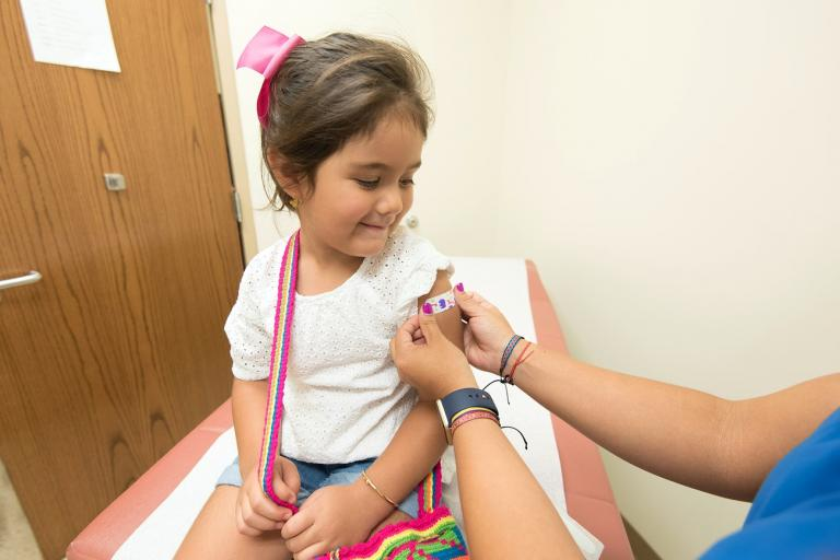 Girl happy after getting vaccinated (CC0 CDC)