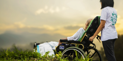 Woman taking a man in a wheelchair to look at the beauty of creation